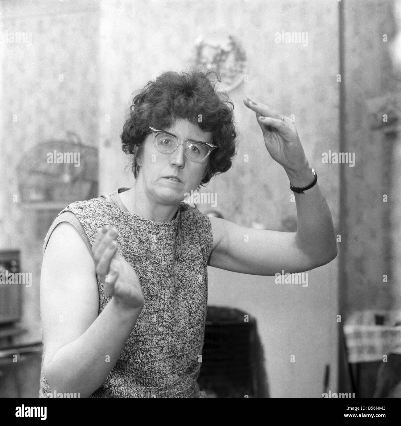 L'humour : Femme portant des lunettes des gestes avec ses mains. Décembre 1969 Z12083 Banque D'Images