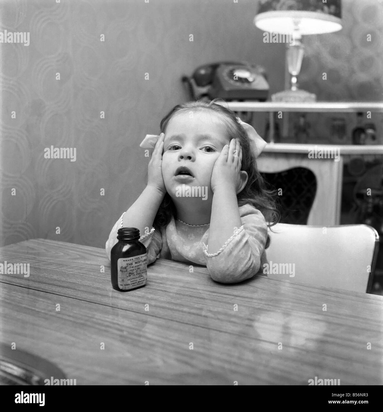Enfants : Une Jeune Fille, Une Bouteille Vide De Comprimés, Ce Qu'elle  Avait Déjà Avalé À Une Fête De Noël Et A Été Transporté À L'hôpital.  Décembre 1969 Z12376-002 Photo Stock -