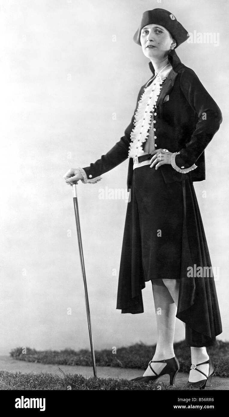 Femme portant veste noire avec la jupe longue et le drapé manteau sur avec  chapeau noir. Dans une main tenant un bâton Janvier 1929 Photo Stock - Alamy