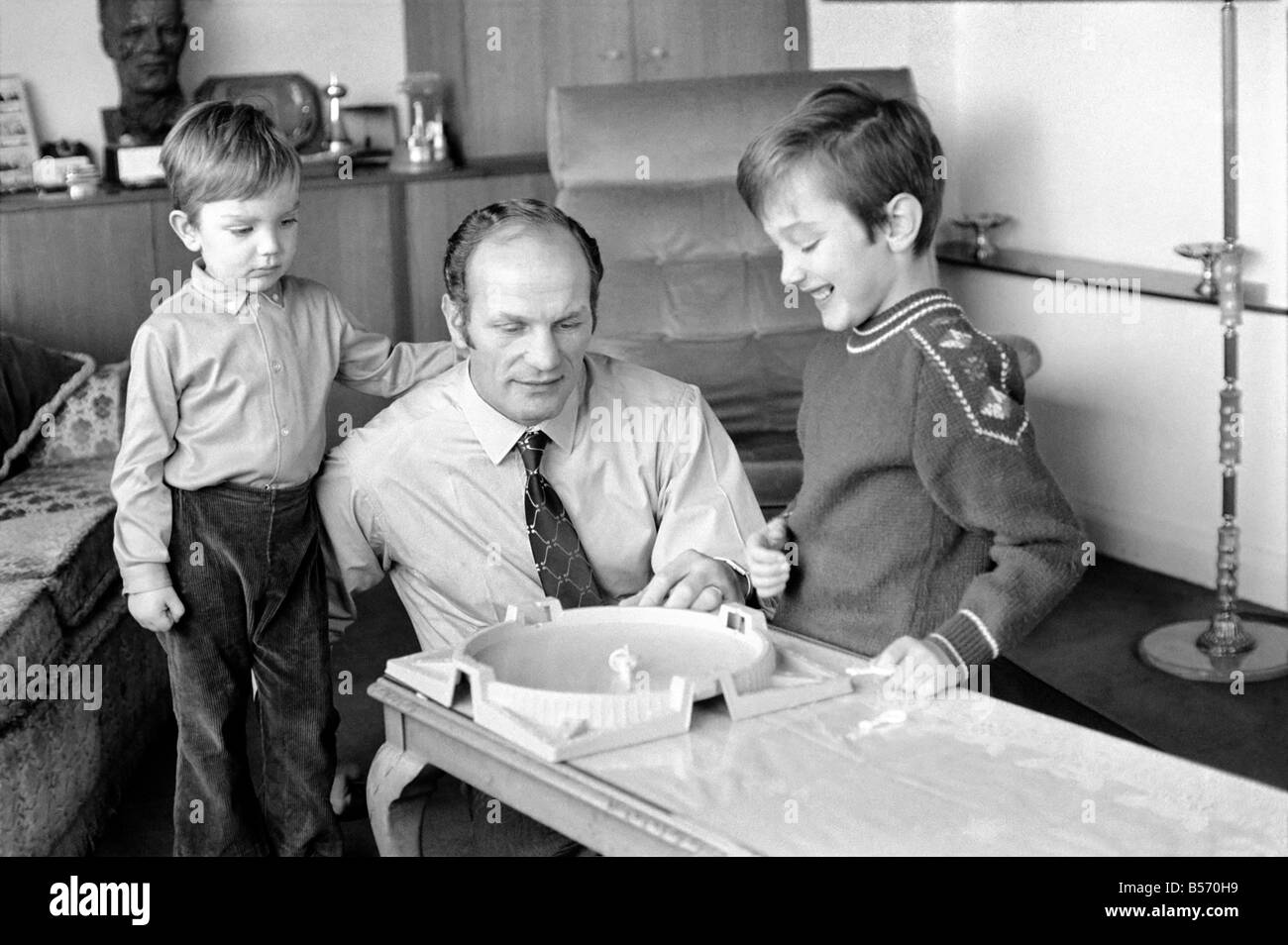 Le boxeur britannique Henry Cooper photographiée avec fils Henry Marco âgés de 10 (à droite) et 3 ans John Pietro jouant avec un jeu de toupies à Wembley son accueil. Décembre 1970 ;70-11690-002 Banque D'Images