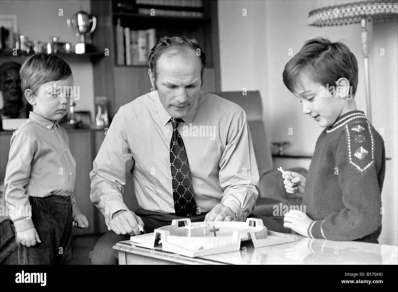 Le boxeur britannique Henry Cooper photographiée avec fils Henry Marco âgés de 10 (à droite) et 3 ans John Pietro jouant avec un jeu de toupies à Wembley son accueil. Décembre 1970 ;70-11690-005 Banque D'Images