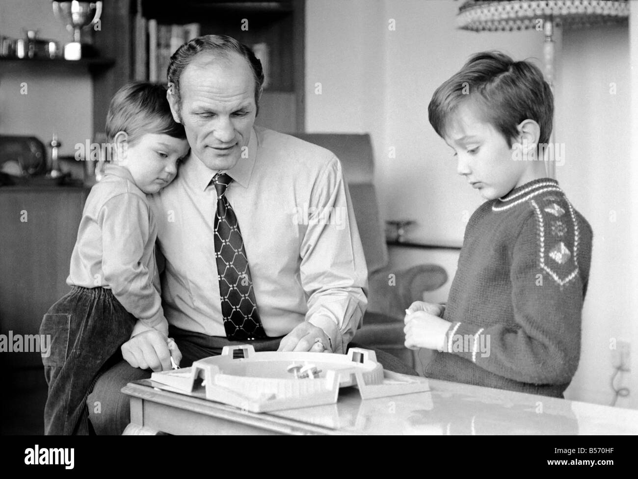 Le boxeur britannique Henry Cooper photographiée avec fils Henry Marco âgés de 10 (à droite) et 3 ans John Pietro jouant avec un jeu de toupies à Wembley son accueil. Décembre 1970 ;70-11690 Banque D'Images