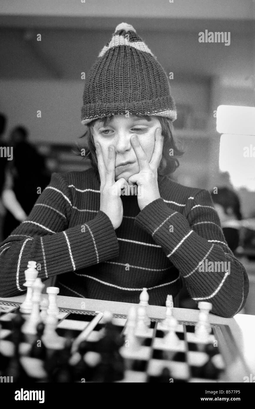 East End Kids Chess Congress : un supporter de West Ham, complet avec son West Ham hat rend une étude de concentration 10 ans Paul Murray de l'École de Cayley, Stepney. Février 1975 75-00950-006 Banque D'Images