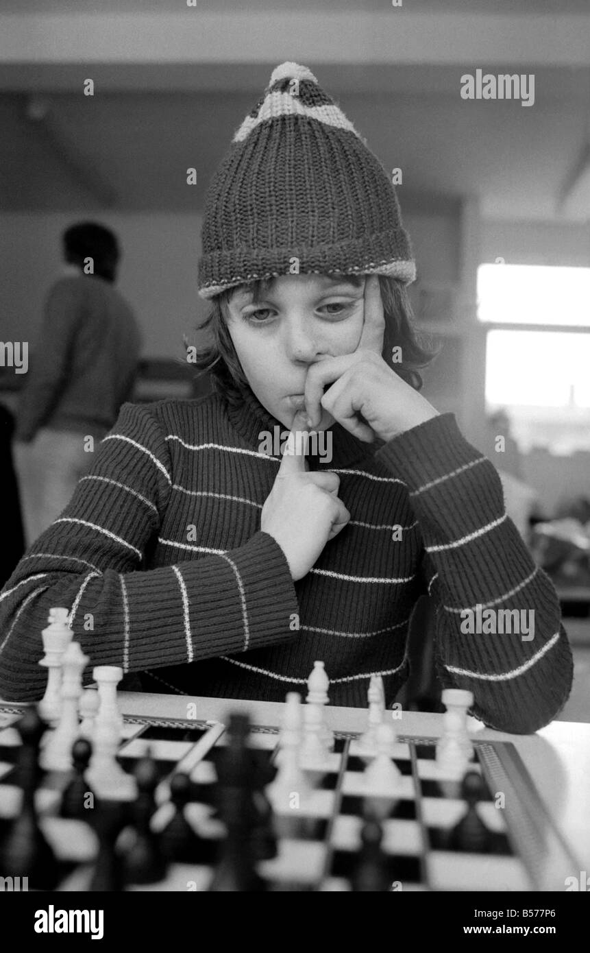 East End Kids Chess Congress : un supporter de West Ham, complet avec son West Ham hat rend une étude de concentration 10 ans Paul Murray de l'École de Cayley, Stepney. Février 1975 75-00950 Banque D'Images