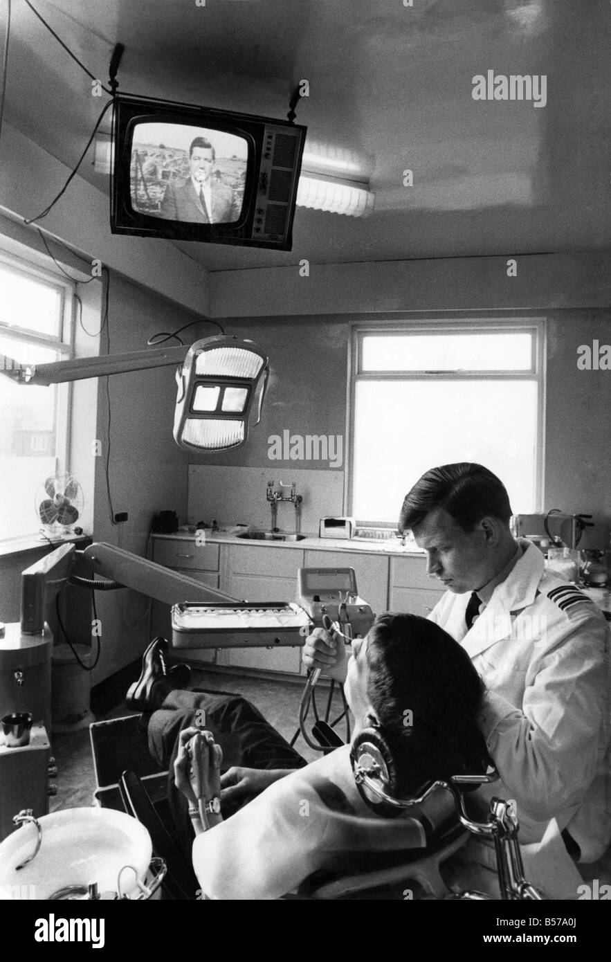 La vie est beaucoup plus facile pour la RAF. Recruter ces jours. Nouvelle recrue Edward Mason (21), prévoit de retour dans le fauteuil et regarde les dentistes d'une émission de télévision tandis que Sqdn. Le Munsford John chef chirurgien dentiste se met au travail sur ses dents. Ce n'est qu'une des idées que le commandant de station group le capt. Jack Bush pensé pour rendre la vie à son poste un peu plus facile. Février 1969 P005302 Banque D'Images