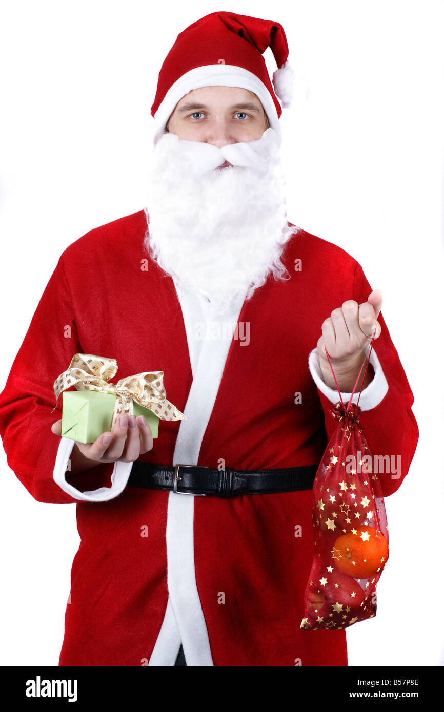 Le Père Noël avec un cadeau et un sac plein de fruits Banque D'Images