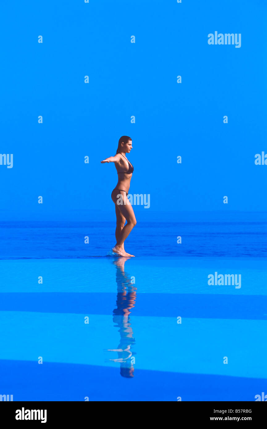 Femme marche au bord d'une piscine à débordement, Maldives, océan Indien, Asie Banque D'Images