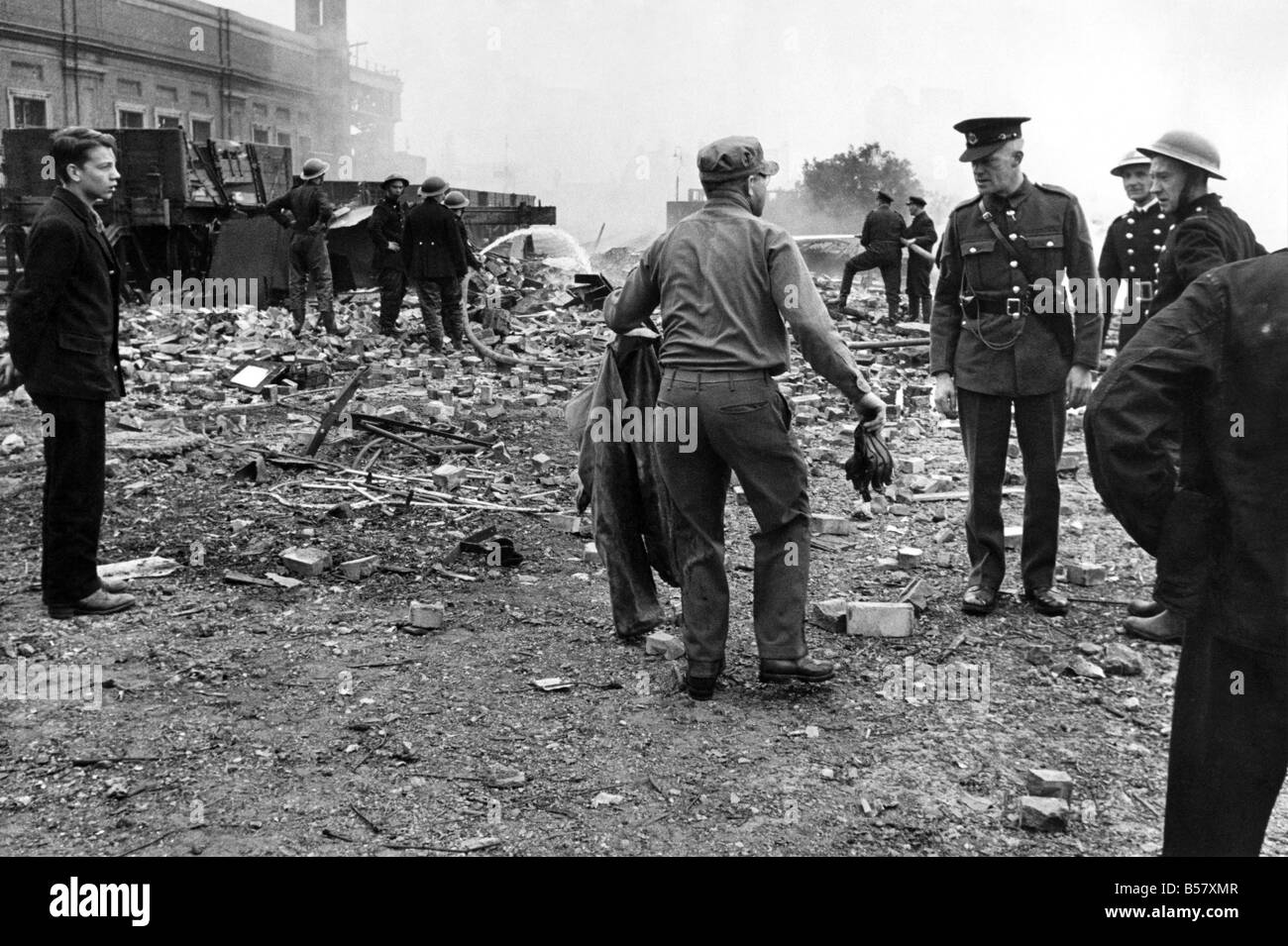 Le soldat américain son décapage de vêtements d'extérieur, au milieu de la scène d'une attaque à la bombe volante V1. ;Juin 1944 * P009481 Banque D'Images