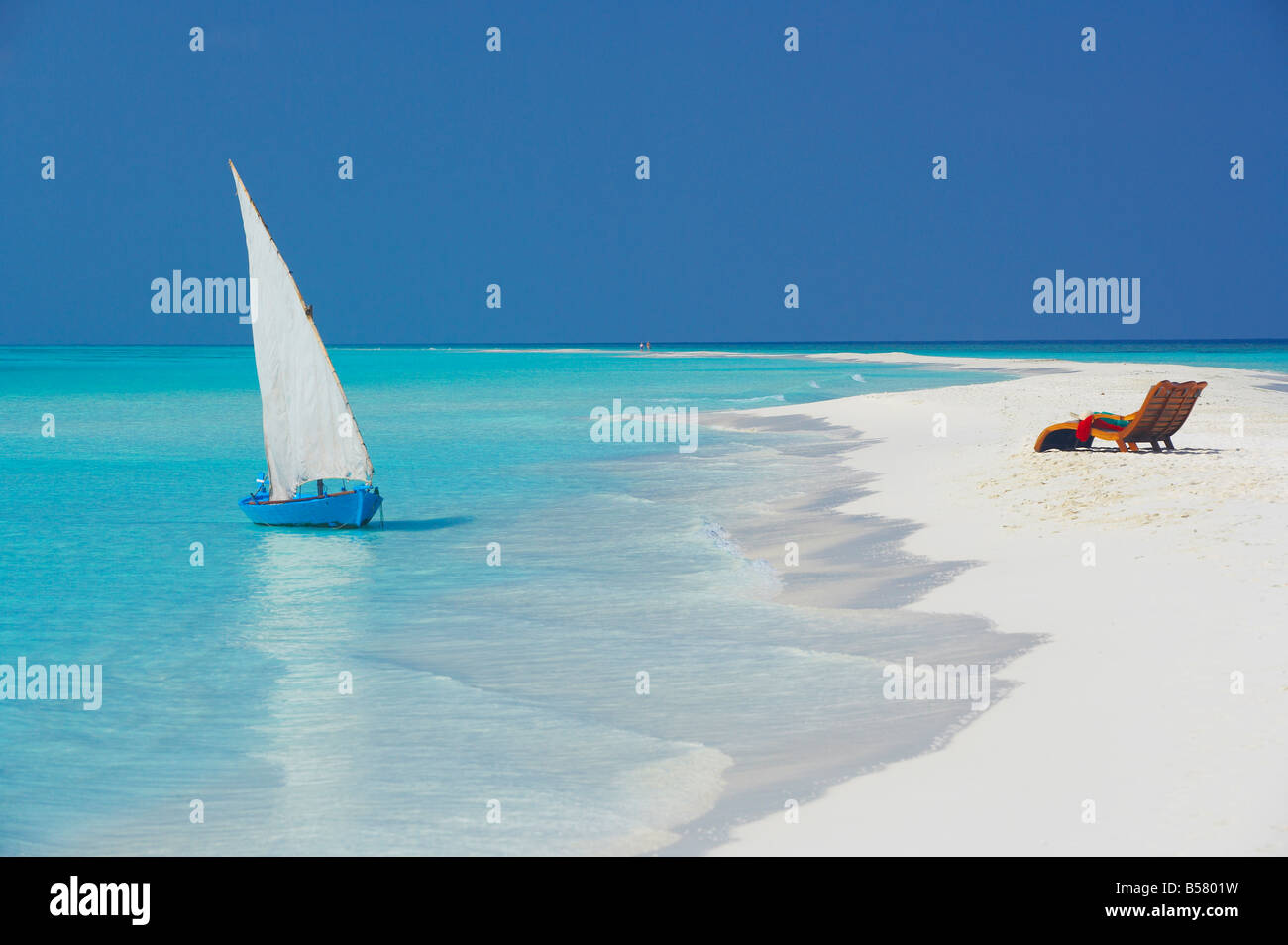 Dhoni traditionnel et des chaises longues sur la plage, Maldives, océan Indien, Asie Banque D'Images