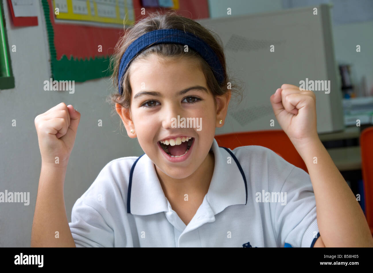 Lycéenne Junior enthousiaste à son bureau dans la salle de classe de l'école Banque D'Images