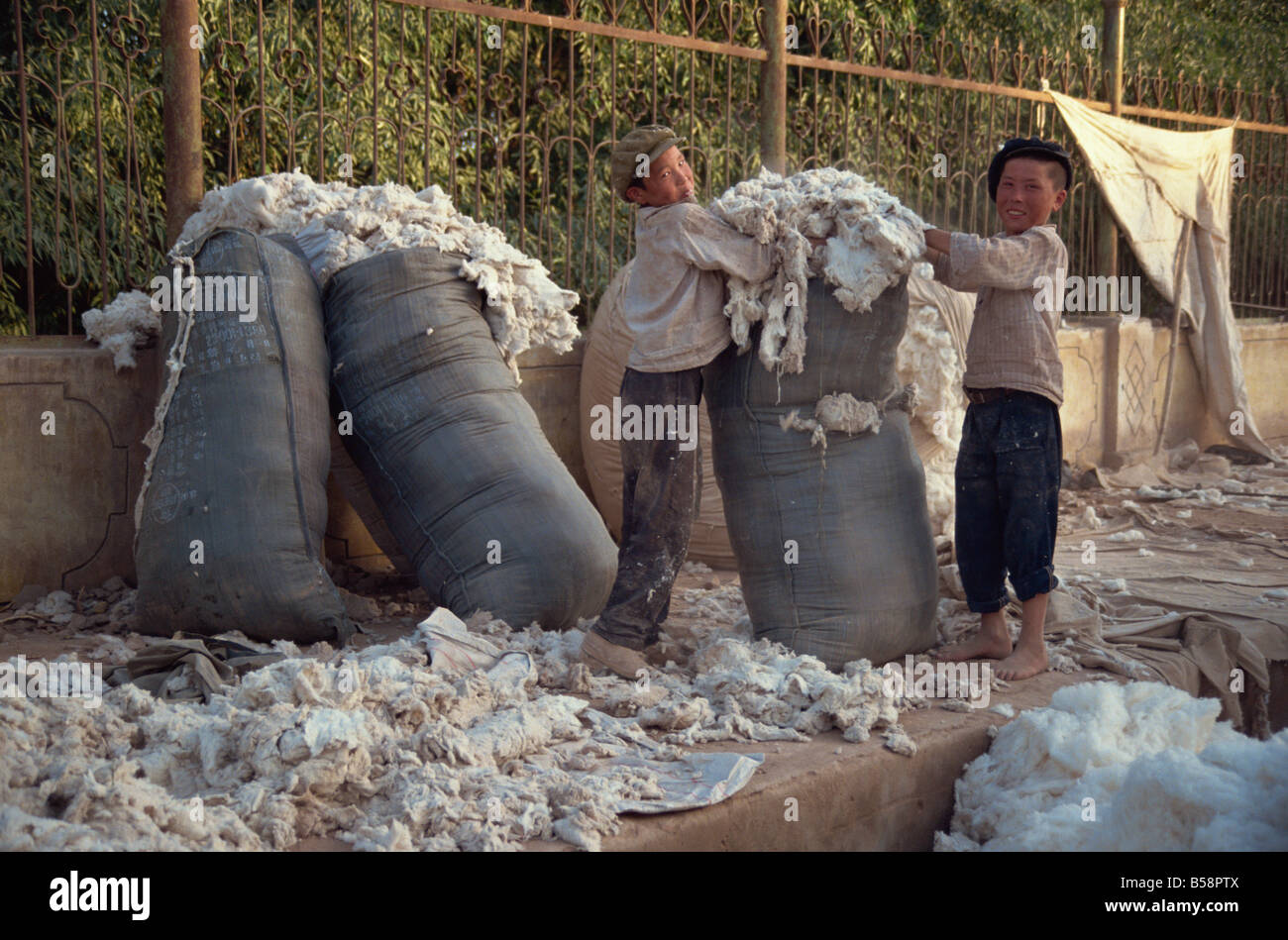 Les enfants de la laine d'emballage à la fin de la journée du marché de l'Asie Chine Kashgar Dimanche Banque D'Images