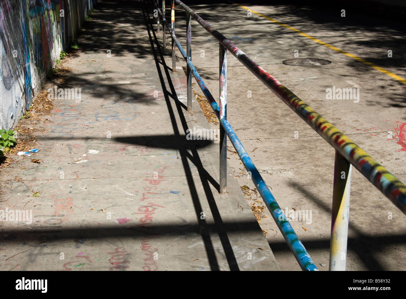 Mains courantes, le trottoir et la rue, recouvertes de peinture à partir de plusieurs couches de graffitis Banque D'Images