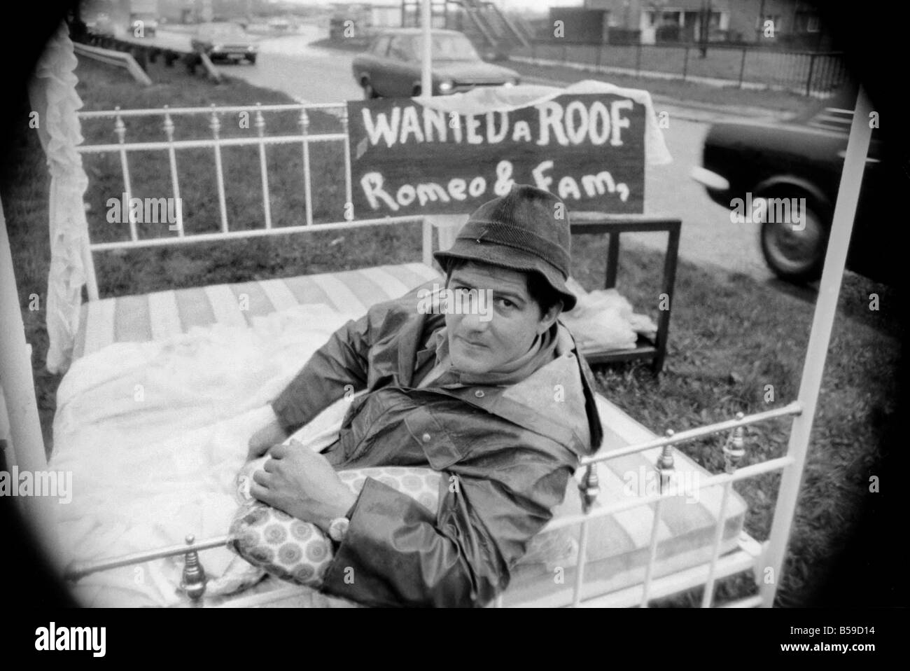 Romeo Meli accroupi contre la pluie battante dans un lit comme les camions de le percer à jour passé. C'est une sieste sur l'herbe de la division d'une double voie de chariot dans une tentative de sauver son vouée cottage. Il est le dernier homme de gauche regrettent la disparition de la déserté de Groes près de Port Talbot, Glam. Les 21 autres familles ont déjà quitté disparu. Avril 1975 75-1947-004 Banque D'Images