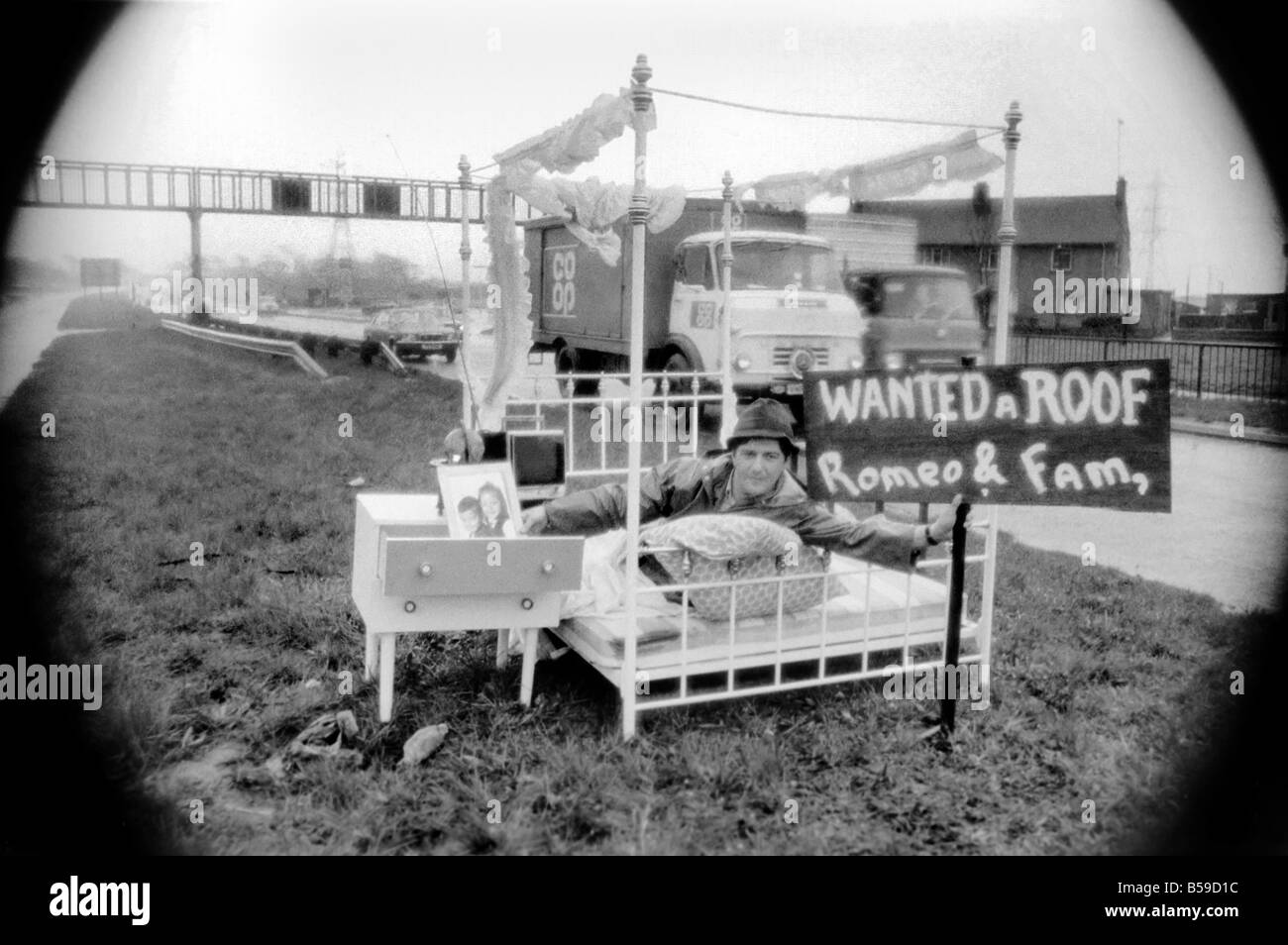 Romeo Meli accroupi contre la pluie battante dans un lit comme les camions de le percer à jour passé. C'est une sieste sur l'herbe de la division d'une double voie de chariot dans une tentative de sauver son vouée cottage. Il est le dernier homme de gauche regrettent la disparition de la déserté de Groes près de Port Talbot, Glam. Les 21 autres familles ont déjà quitté disparu. Avril 1975 75-1947 Banque D'Images