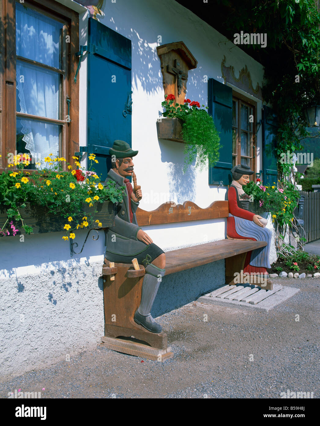 Figures sculptées sur un banc sur une maison de décoration/à Garmisch Partenkirchen en Bavière Allemagne G Hellier Banque D'Images
