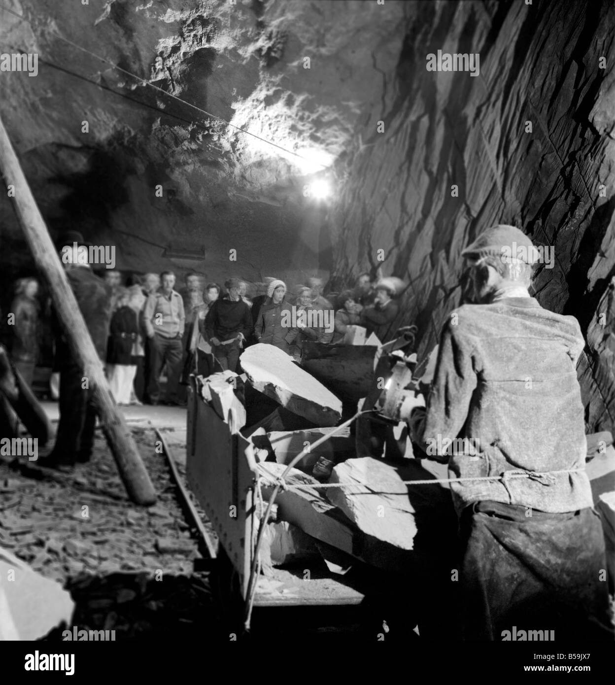 L'industrie minière : : 'Britain's Beauty Spot plus laid' : Blaenau Ffestiniog, un village de mineurs d'ardoise galloise, où les chefs des scories giat tour Ardoise haut au-dessus des toits et plonger jusqu'aux portes des maisons, est devenu une des principales attractions touristiques. Plus de 2 000 touristes par jour troupeau de faire une visite guidée autour de la mine d'Ardoise de Llechwedd - menées par les mineurs, les mêmes hommes qui avaient l'habitude d'une griffe peu dangereux et vivre de la montagne lors de l'extraction de l'ardoise est à son apogée. Ouvriers du modèle sont utilisés pour illustrer comment le travail a été effectué, à l'intérieur de la grande caverne Banque D'Images