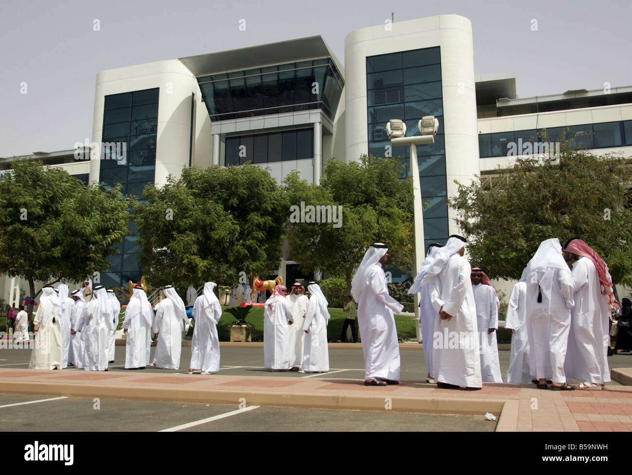 Les hommes arabes en face de l'entrée de la Nad Al Sheba horse race course, Dubaï, Émirats Arabes Unis Banque D'Images