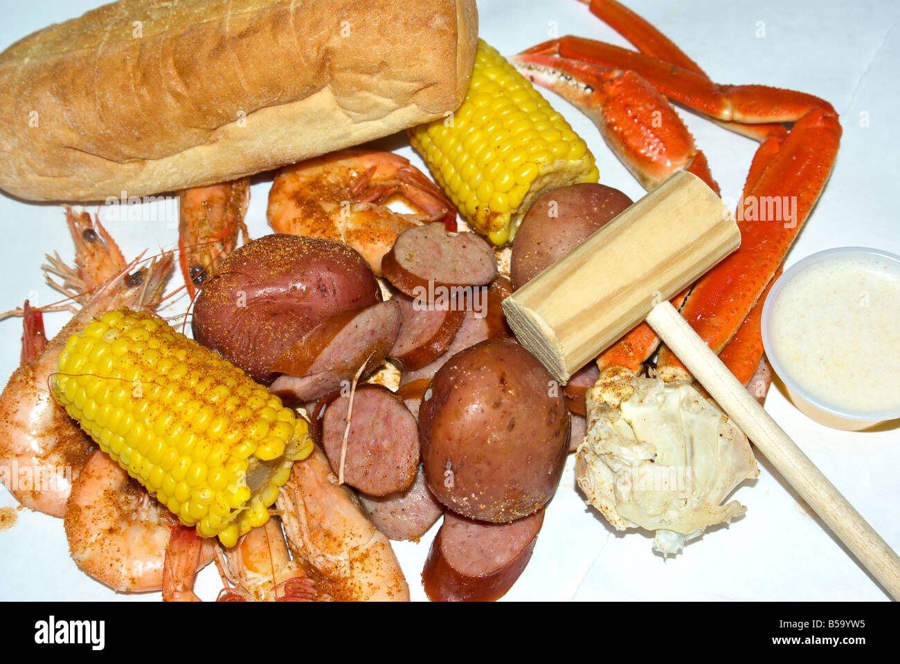 Plateau de fruits de mer aux épices cajun crabe des neiges de la crevette du golfe de pommes de terre saucisse fumé des épis de maïs pain beurre fondu tremper Banque D'Images