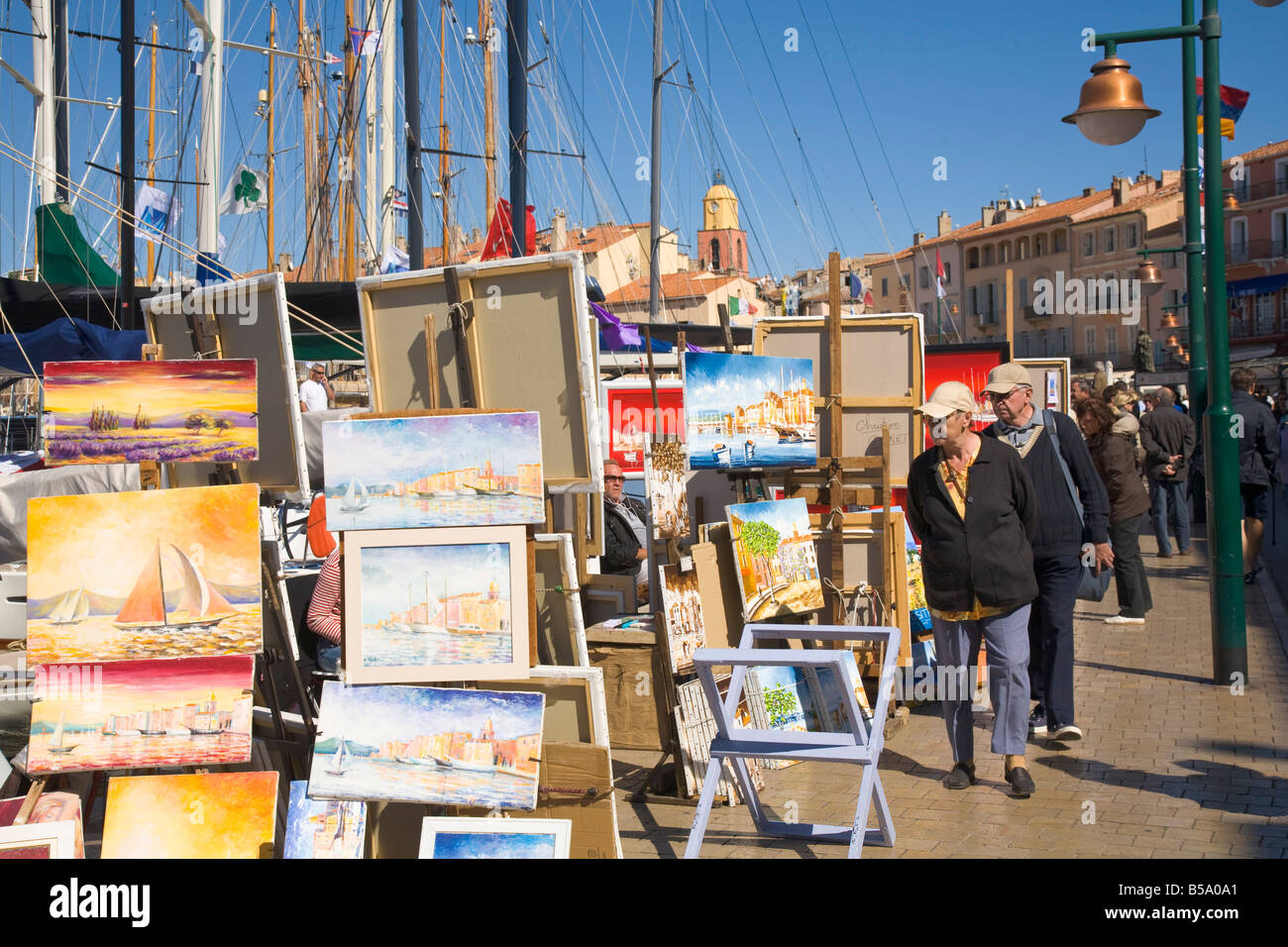 Les touristes regarder peintures qui sont affichées dans le port de Saint-Tropez sur la Cote d'Azur / Provence / Sud de la France Banque D'Images