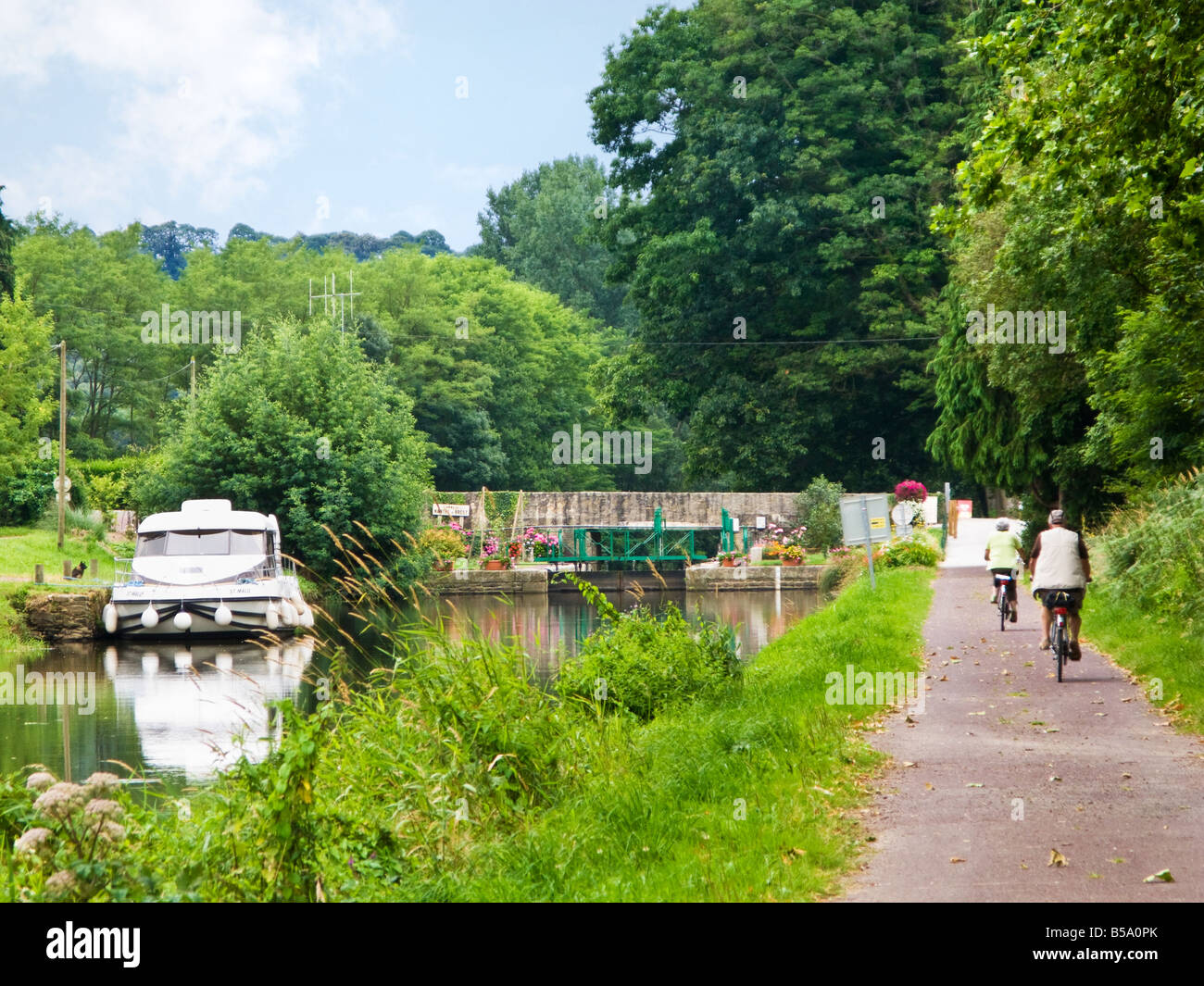 Les cyclistes sur le chemin de halage à une écluse sur le Canal de