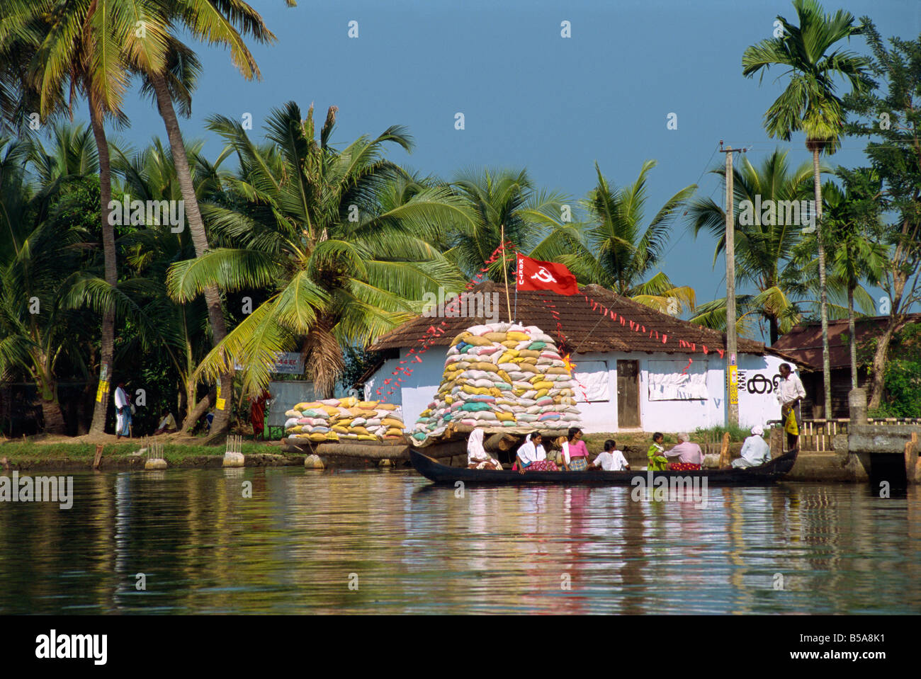 Petit bateau passant drapeau communiste, Backwaters, Kerala State, India Banque D'Images
