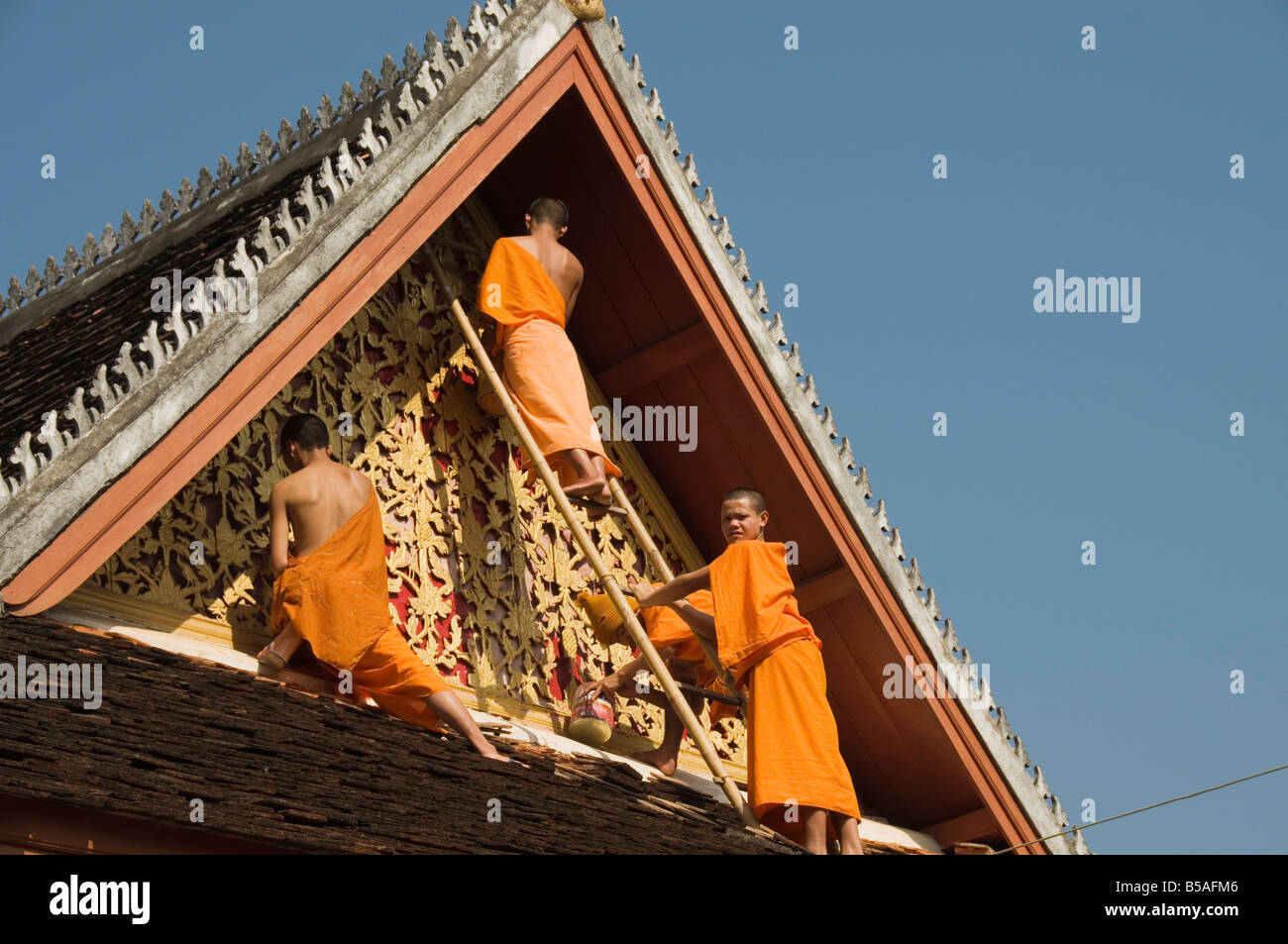 Moines, sur le toit du temple de peinture décorations, Wat Mai, Luang Prabang, Laos, Indochine, Asie du sud-est Banque D'Images