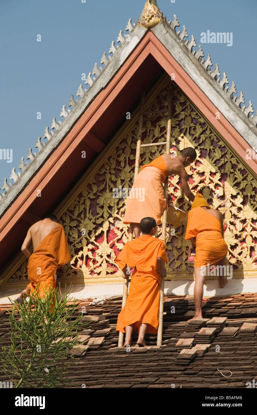 Moines, sur le toit du temple de peinture décorations, Wat Mai, Luang Prabang, Laos, Indochine, Asie du sud-est Banque D'Images
