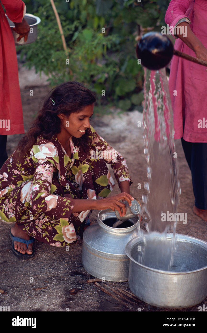 Les femmes vont chercher de l'eau, Maldives, océan Indien Banque D'Images