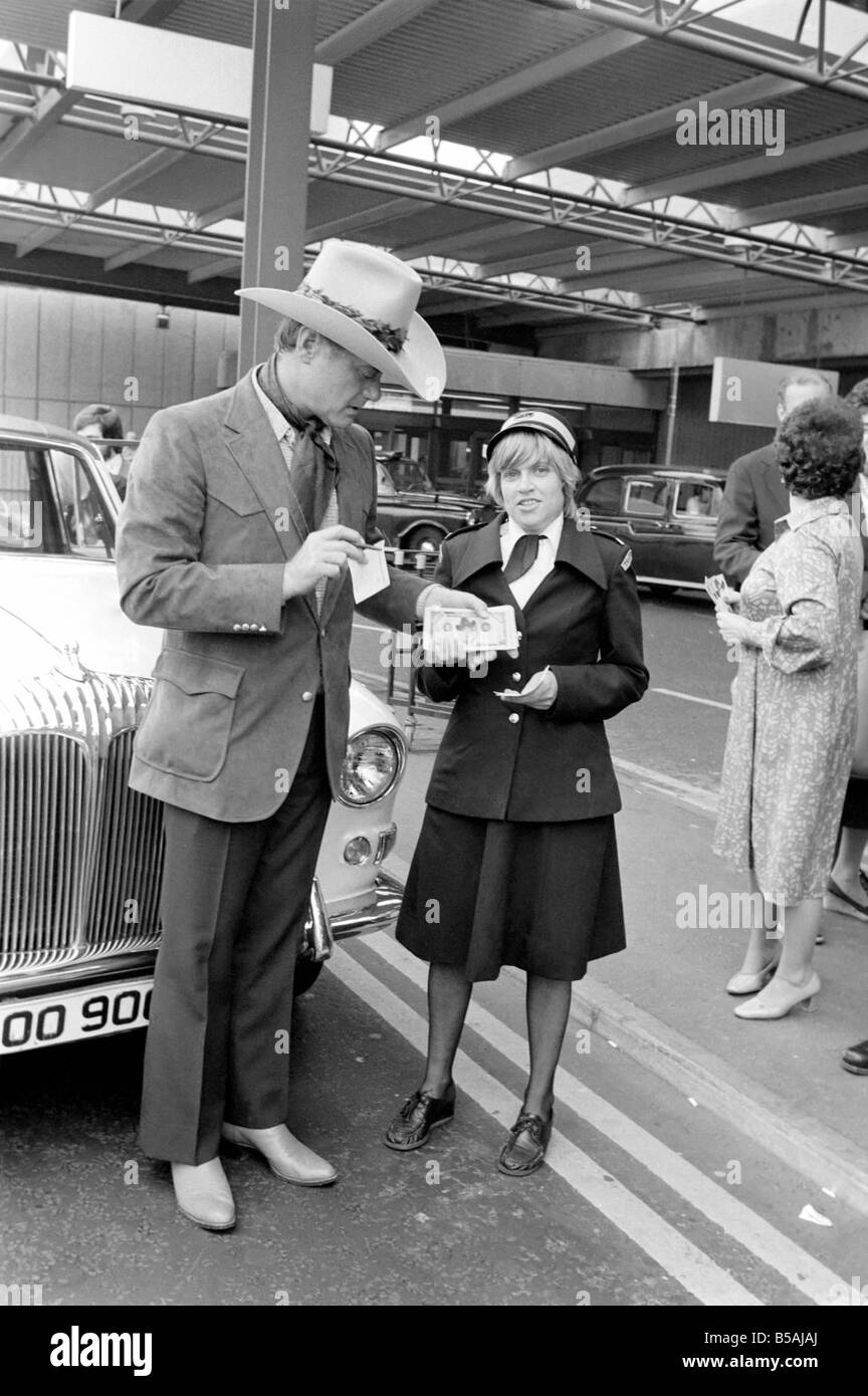 Télévision : Larry Hagman, acteur de J.R. de Dallas Ewing, et sa femme le Maj arrivent à l'aéroport d'Heathrow à Londres. Larry Hagman avec traffic Warden Ann Holland (29) qui a refusé de la loi sur les faux en disant qu'elle ne pouvait pas accepter un pot-de-vin. Juin 1980 80-03022 Banque D'Images