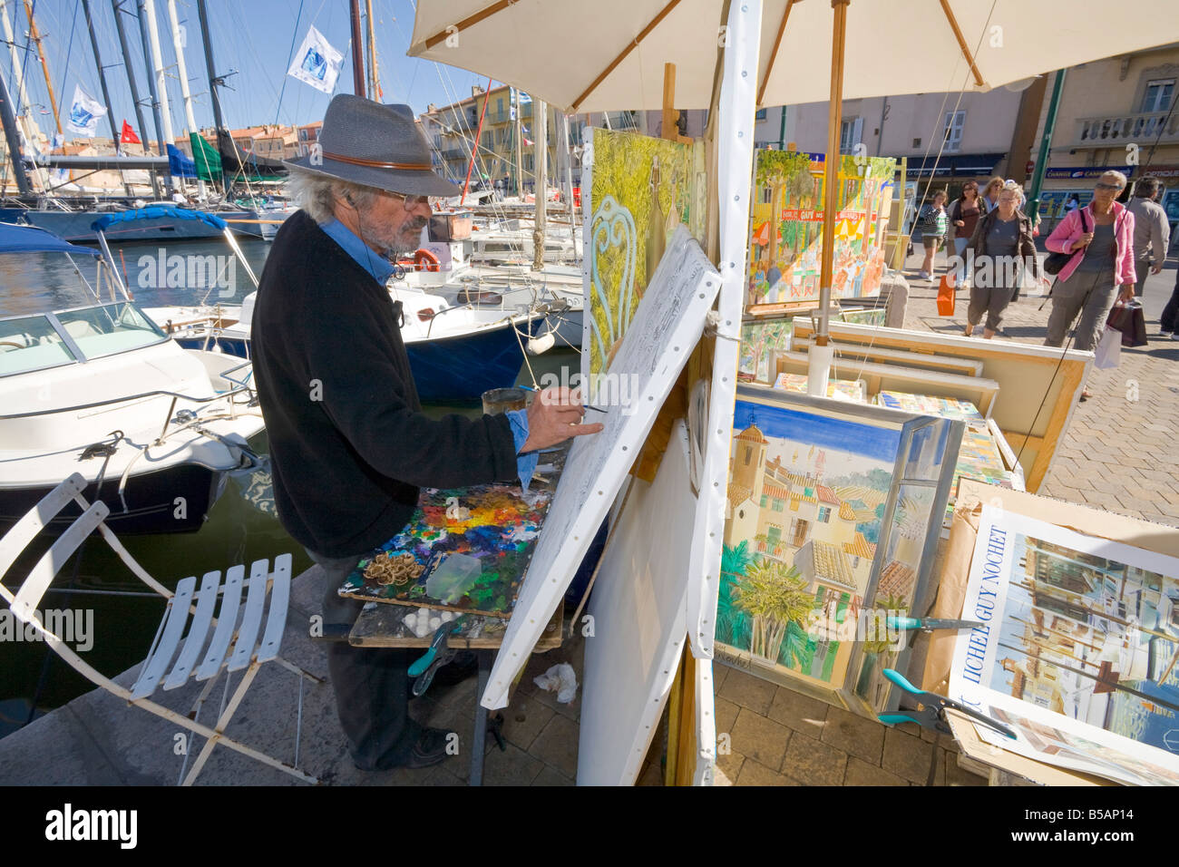 Guy peintre Nochet travaille sur une peinture au port de Saint-Tropez sur la Cote d'Azur / Provence / Sud de la France Banque D'Images