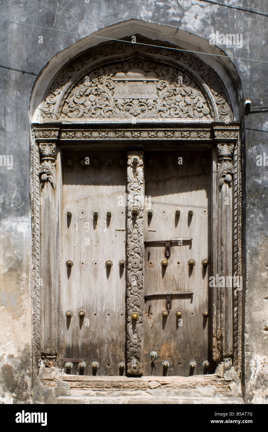 Une porte en bois finement sculptés en arabe Stone Town Zanzibar Tanzanie Afrique de l'Est Banque D'Images