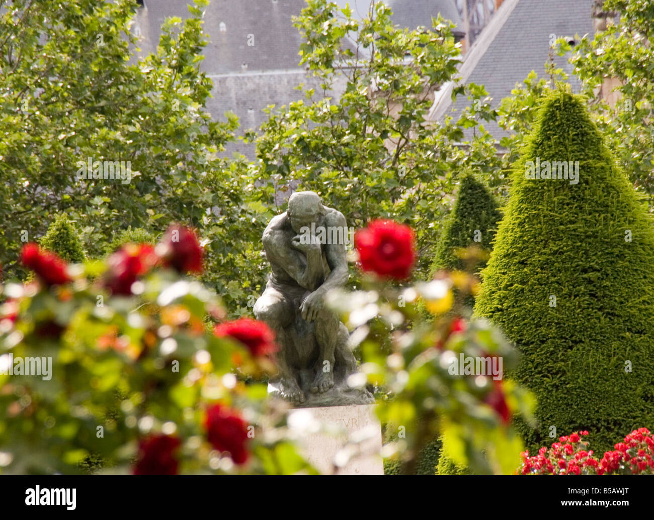 La célèbre sculpture de Rodin "Le Penseur" est assis et contemple le jardin de roses au Musée Rodin à Paris. Banque D'Images