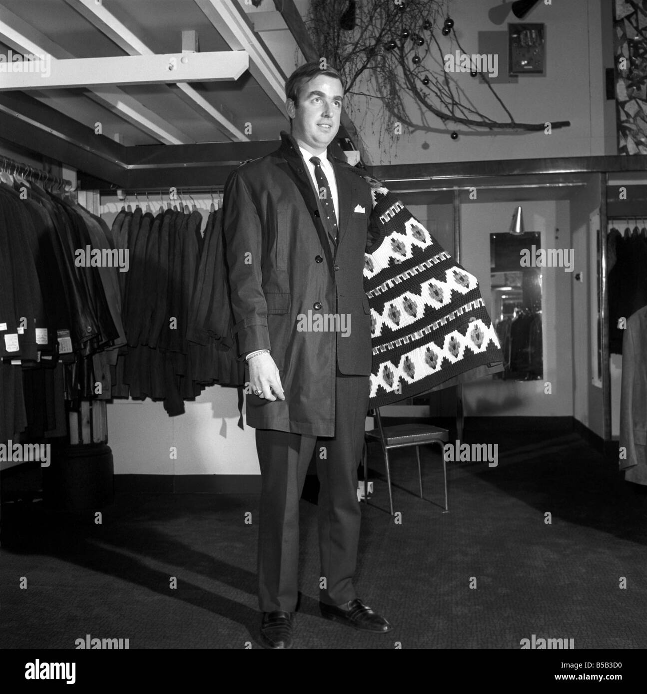 Modèle masculin portant un manteau de magasin. 1966 Banque D'Images