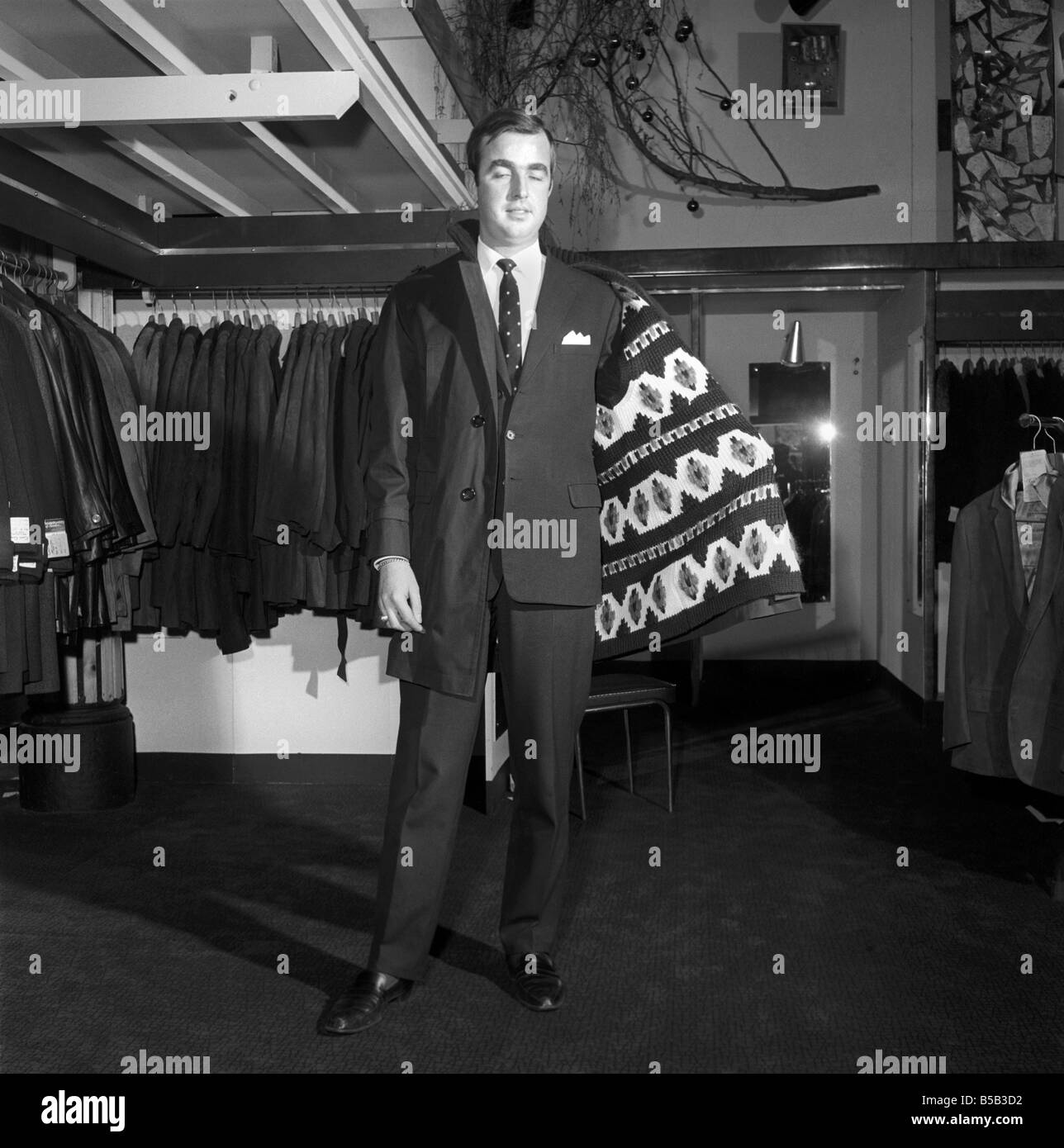 Modèle masculin portant un manteau de magasin. 1966 Banque D'Images