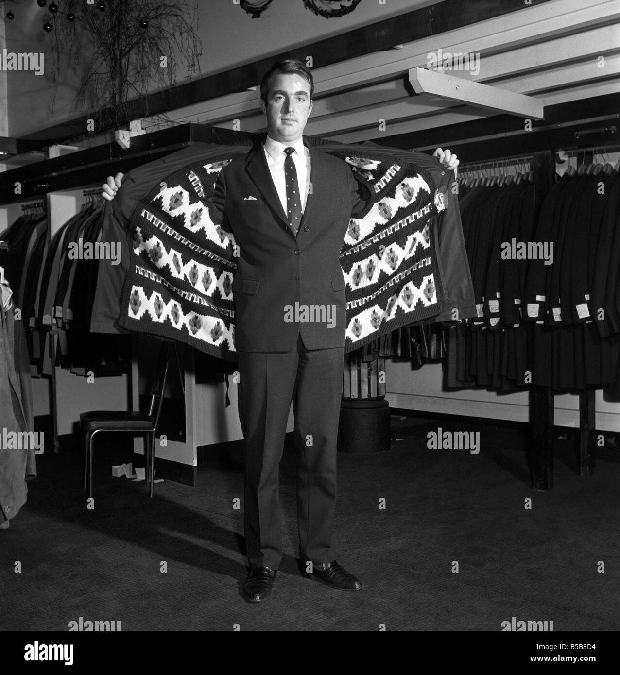 Modèle masculin portant un manteau de magasin. 1966 Banque D'Images