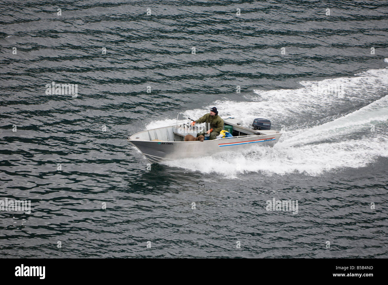 Un homme et son chien en bateau de pêche en canal de l'Est près de Sitka, Alaska Banque D'Images