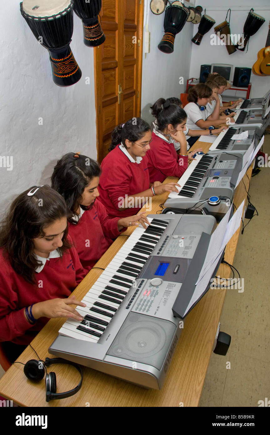 CLAVIERS de CLASSE musicale les élèves de Teenage s'entraîner ensemble sur des claviers électroniques dans la classe de musique scolaire Banque D'Images