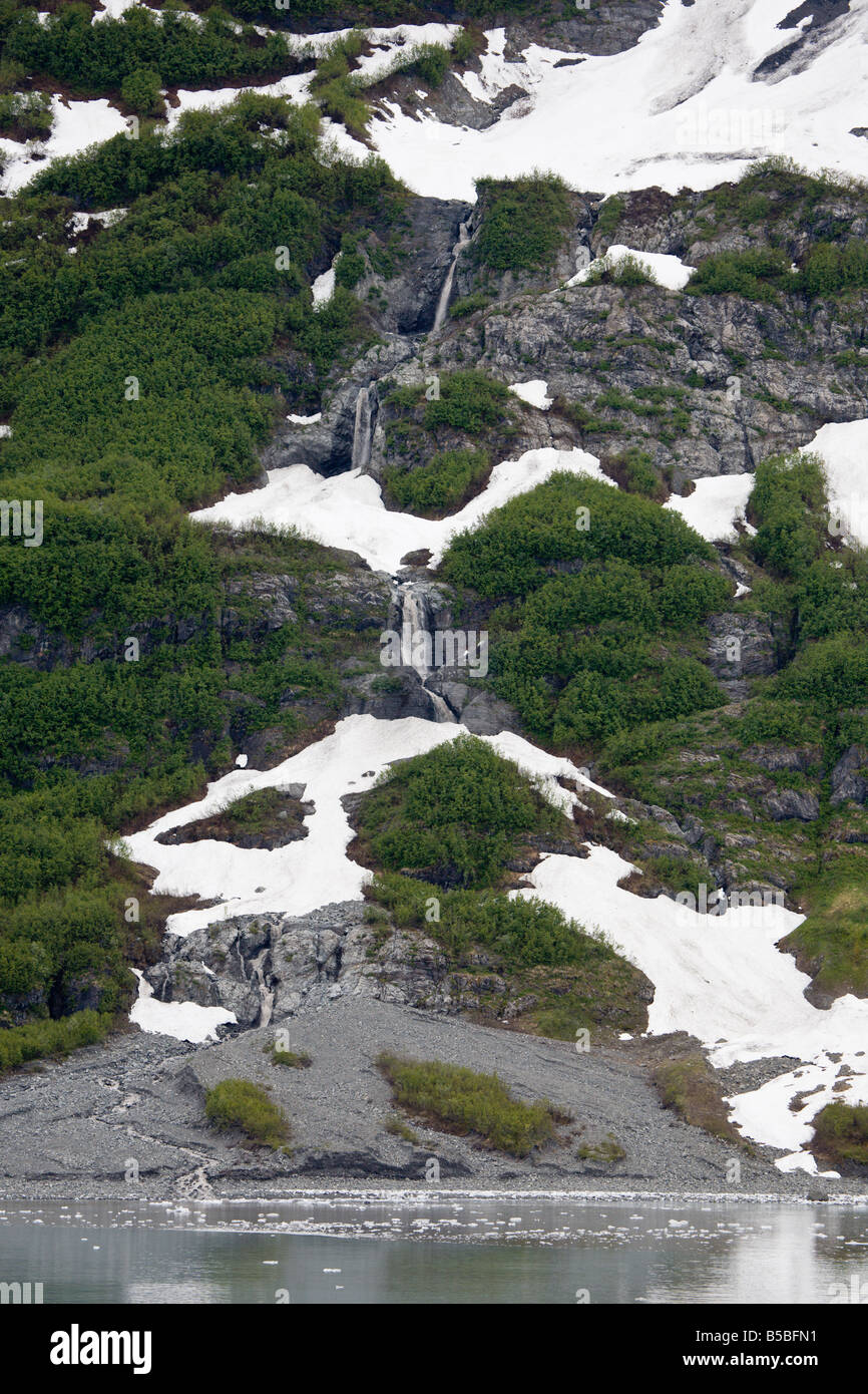 L'écoulement glaciaire passé rocky mountain waterfall in désenchantement Bay en Alaska Banque D'Images