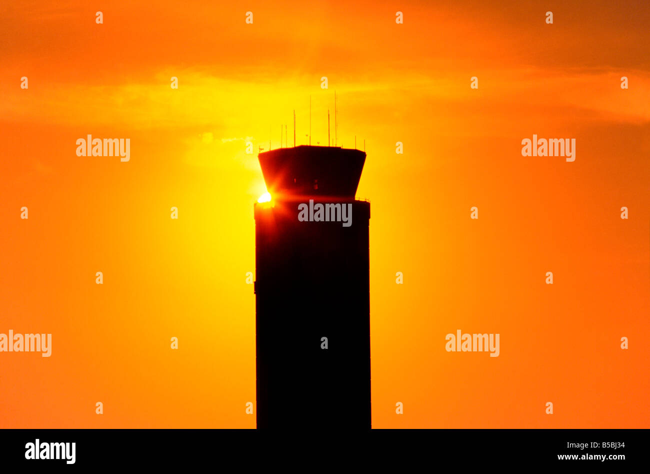 Soleil se couche derrière la tour de contrôle de l'aéroport, l'Aéroport International d'Orlando Banque D'Images