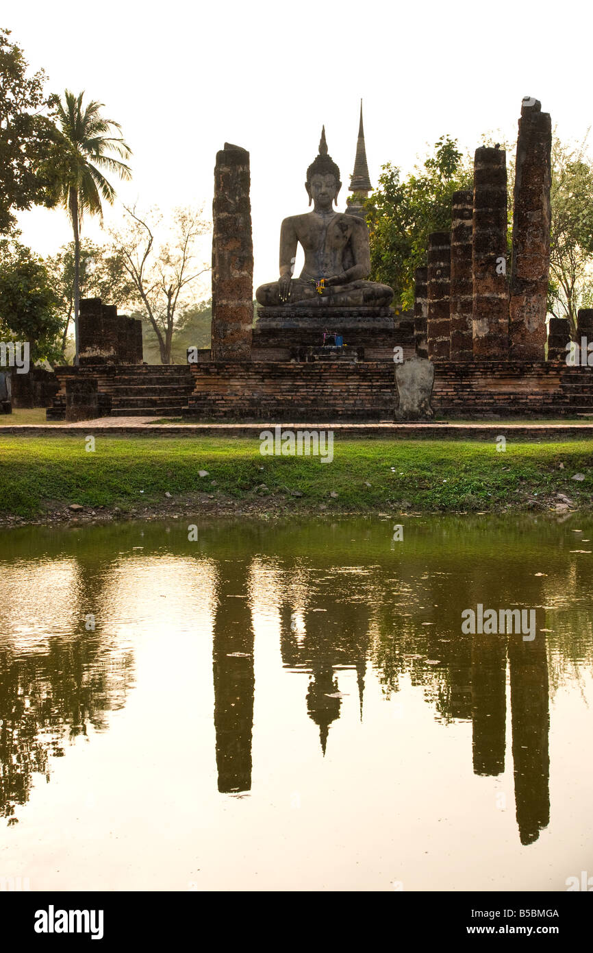 Statue de Bouddha dans le temple Wat Mahathat parc historique de Sukhothai en Thaïlande, au coucher du soleil Banque D'Images