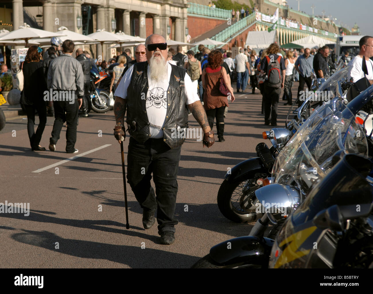 Le vieillissement de biker promenades avec un bâton à l'événement moto Brightona sur le front de mer de Brighton UK Banque D'Images
