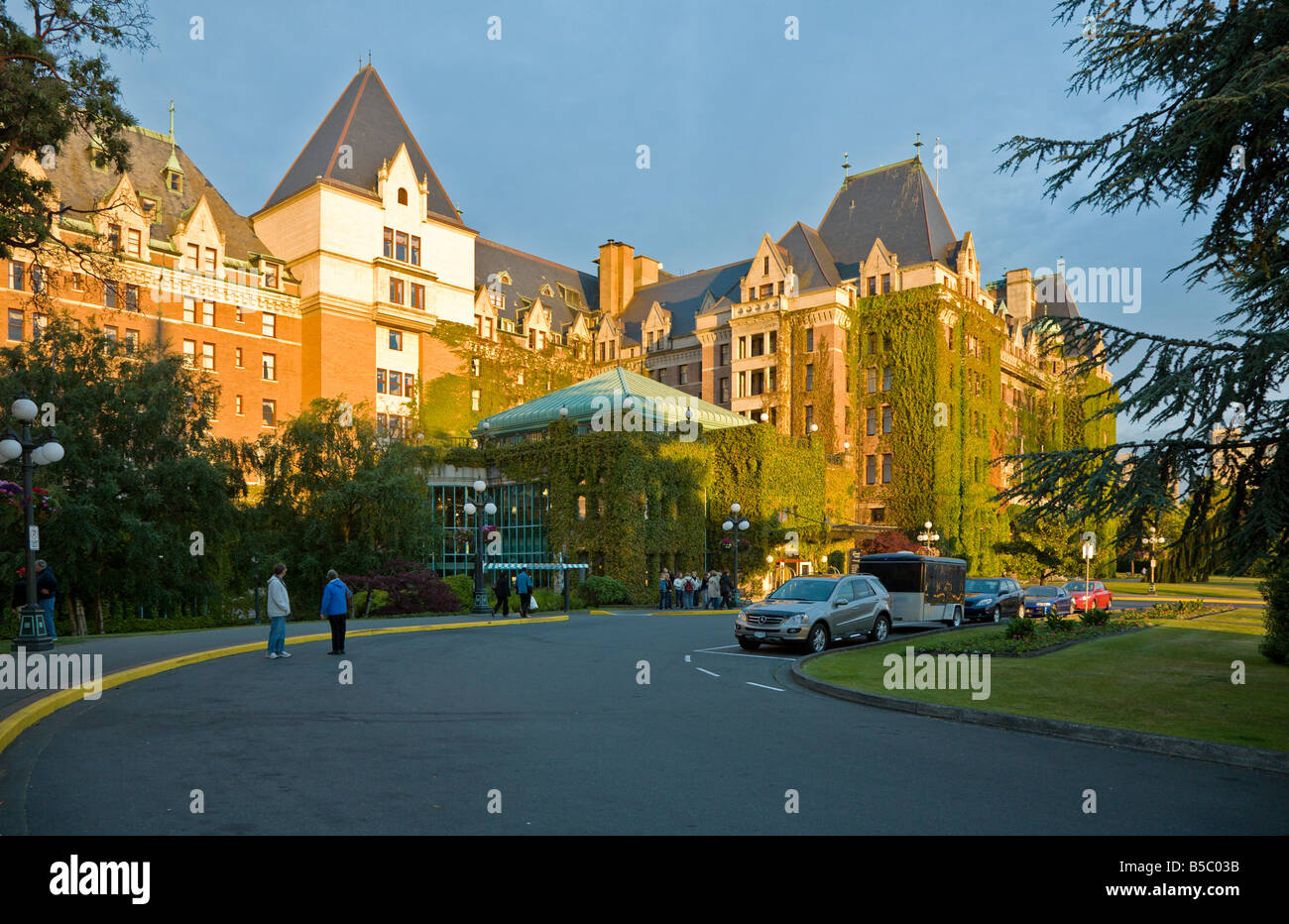 Touristes se mêlent au coucher du soleil à l'extérieur de l'hôtel Resort The Fairmont Empress à Victoria, Colombie-Britannique, Canada Banque D'Images