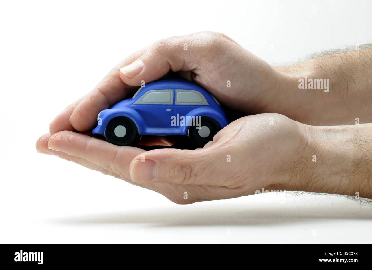 Un modèle voiture couvert et protégé par un homme de main. RE ASSURANCE AUTO ACCIDENT SÉCURITÉ PROTECTION PRIMES MOTORING FAMILLE LAPIN UK Banque D'Images