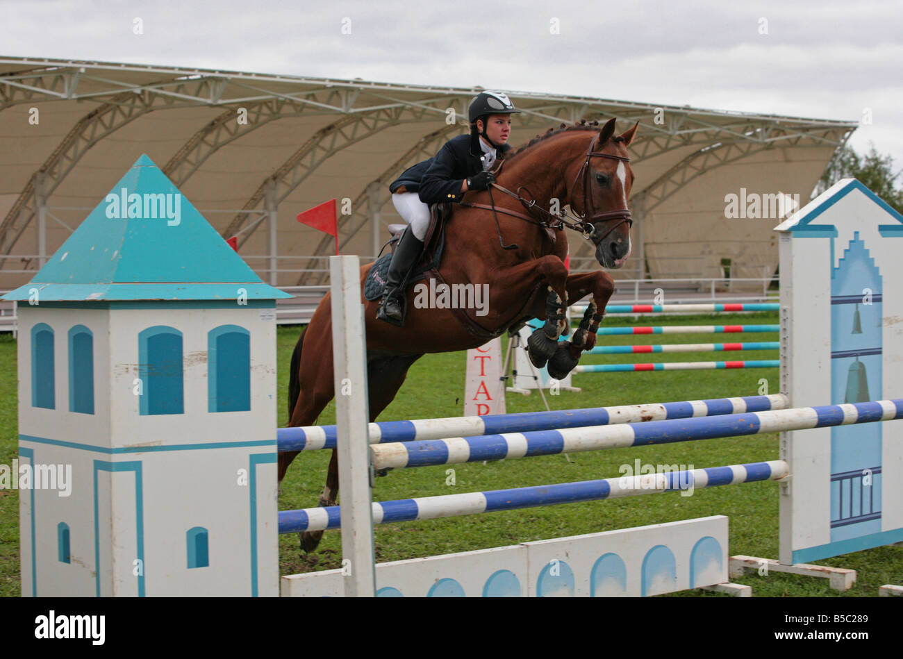 Jeune dame-cavalier sautant sur le dos d'un cheval allemand Banque D'Images