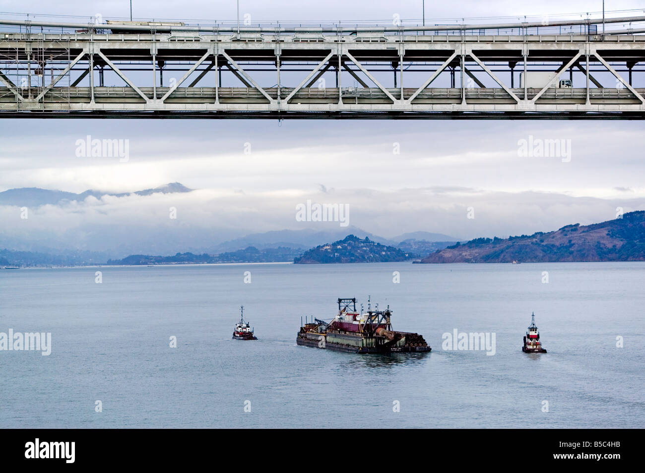 Vue aérienne au-dessus de remorqueurs tirant sur une barge à San Francisco Oakland Bay Bridge Banque D'Images