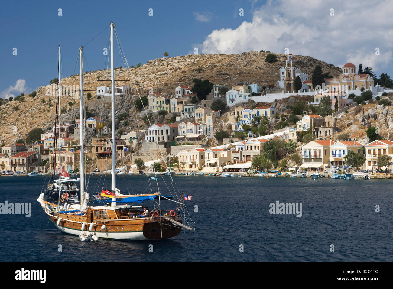 Des bateaux et des maisons sur le port pittoresque de Yialos, sur l'île de Symi, Grèce Banque D'Images Des bateaux et des maisons sur le port pittoresque de Yialos, sur l'île de Symi, Grèce Banque D'Images