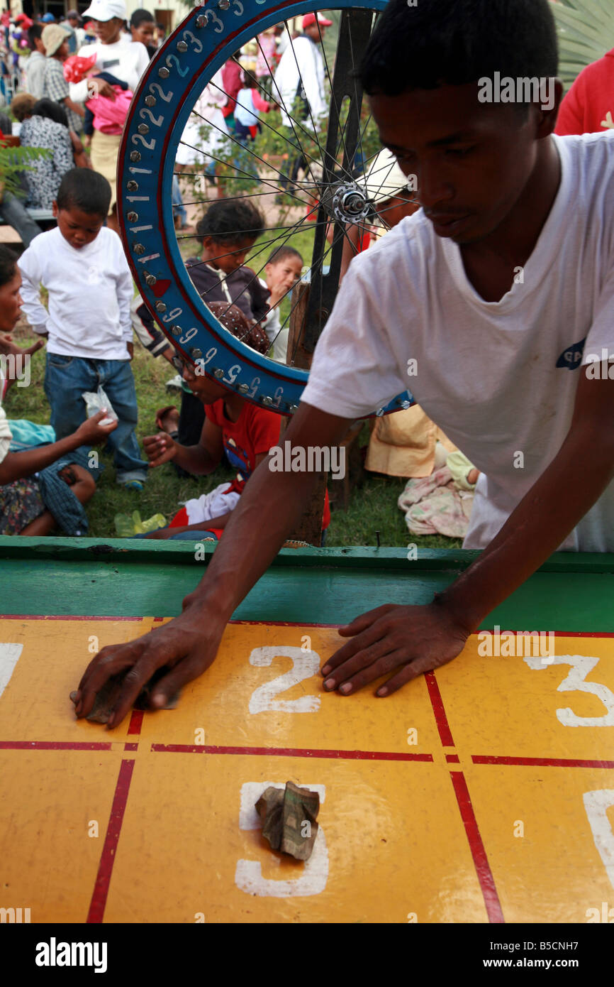 Un homme donnant à l'arrière de l'argent à un gagnant au loto à la traditionnelle foire de mai à Antanarivo Madagascar Banque D'Images