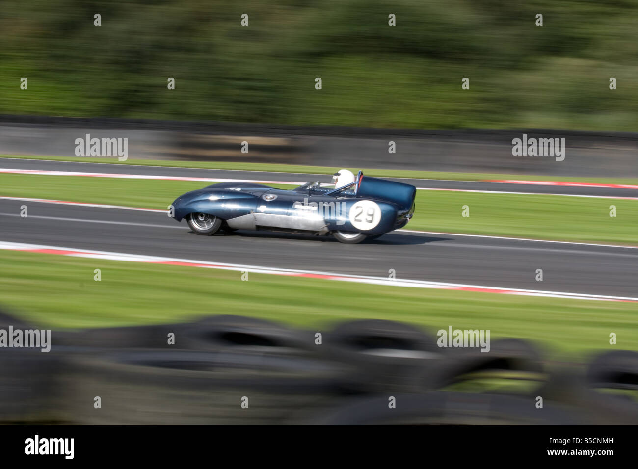 Une vitesse d'obturation lente panoramique d'une vieille voiture classique à Oulton Park dans le Cheshire en Angleterre. Banque D'Images