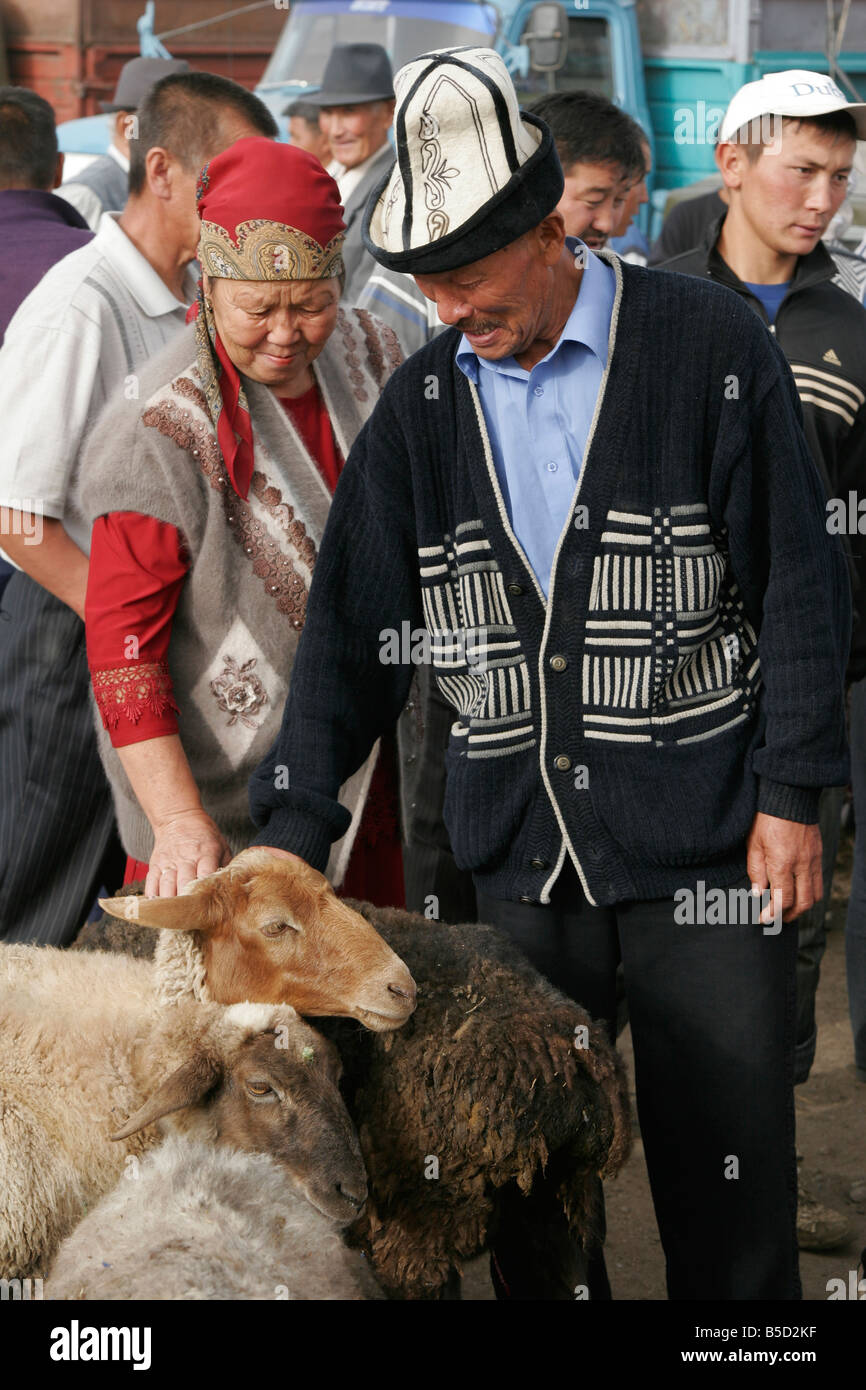 Couple kirghize des moutons pour acheter au marché des animaux, dimanche à Karakol, le Kirghizistan, l'Asie centrale Banque D'Images