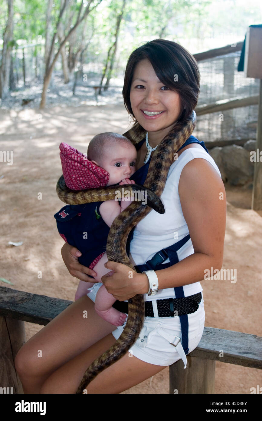 Une mère et bébé garçon posent avec un serpent python autour du cou à  Townsville s Billabong Sanctuary Photo Stock - Alamy